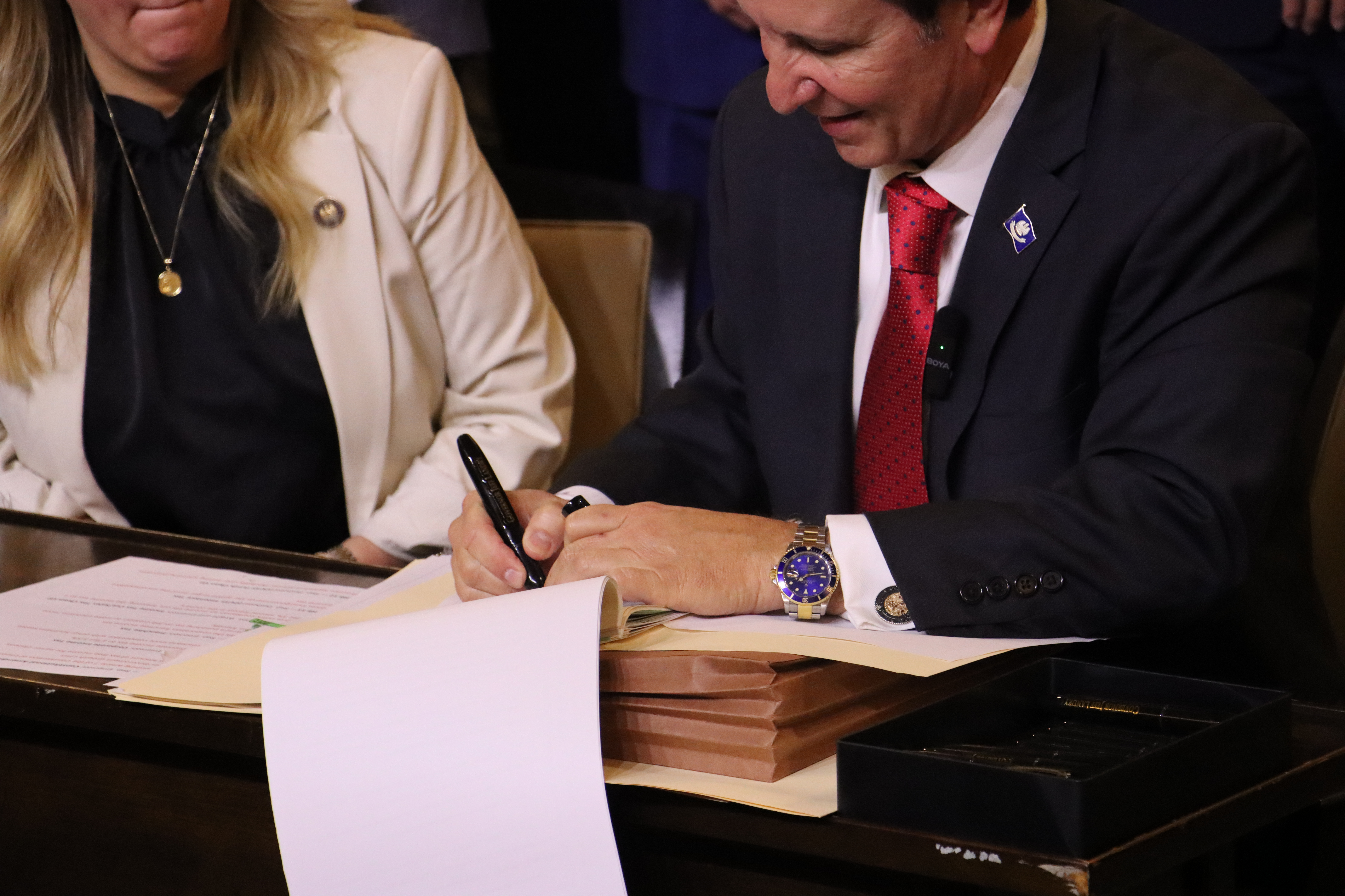 Photograph of Governor Landry signing documents