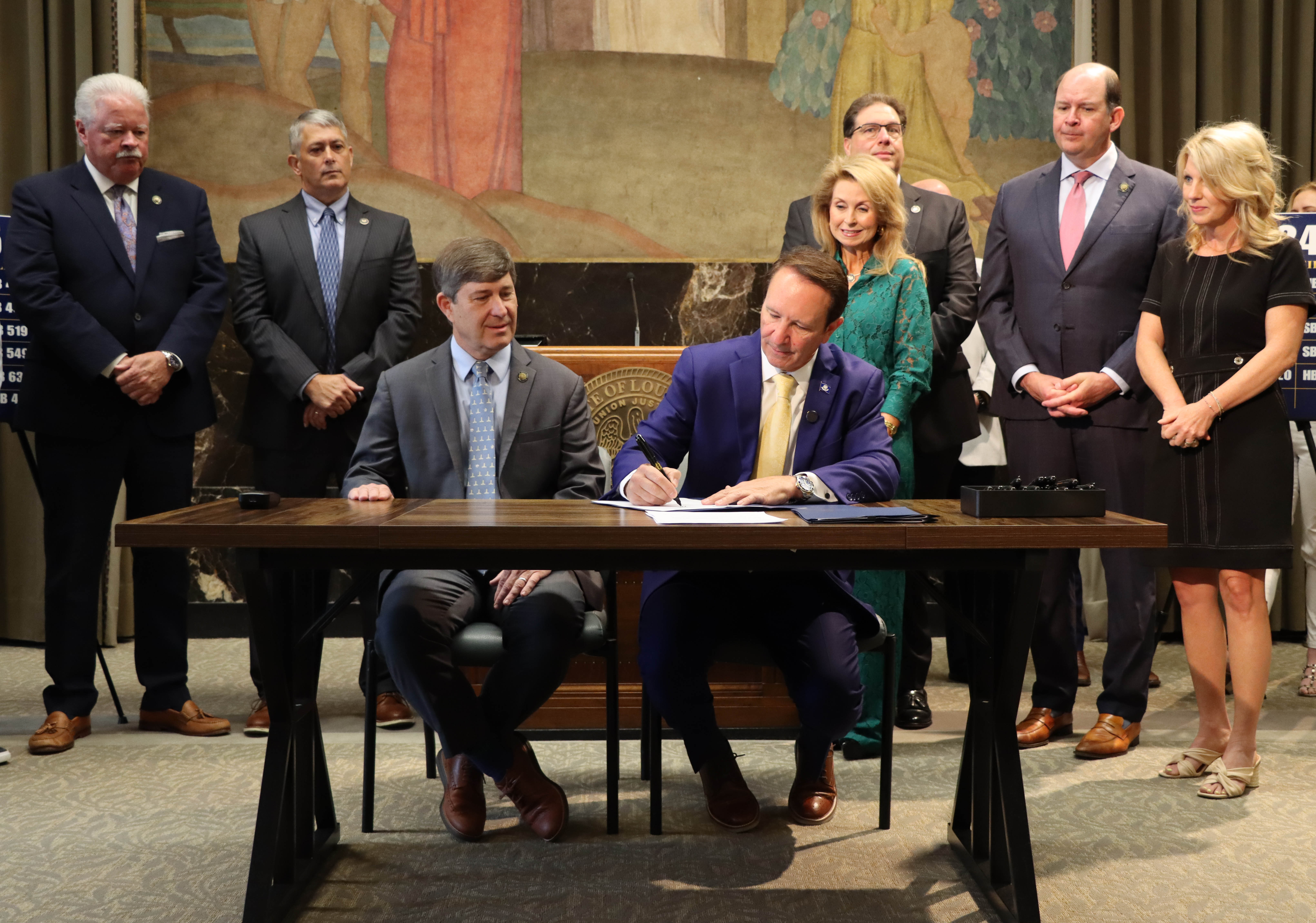 Photograph of Governor Landry signing documents